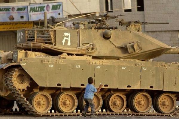 Palestinian faces Israeli tank